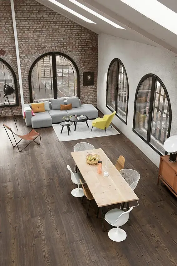 Loft mit Rundbogenfenstern und Esstisch auf Eichendielen