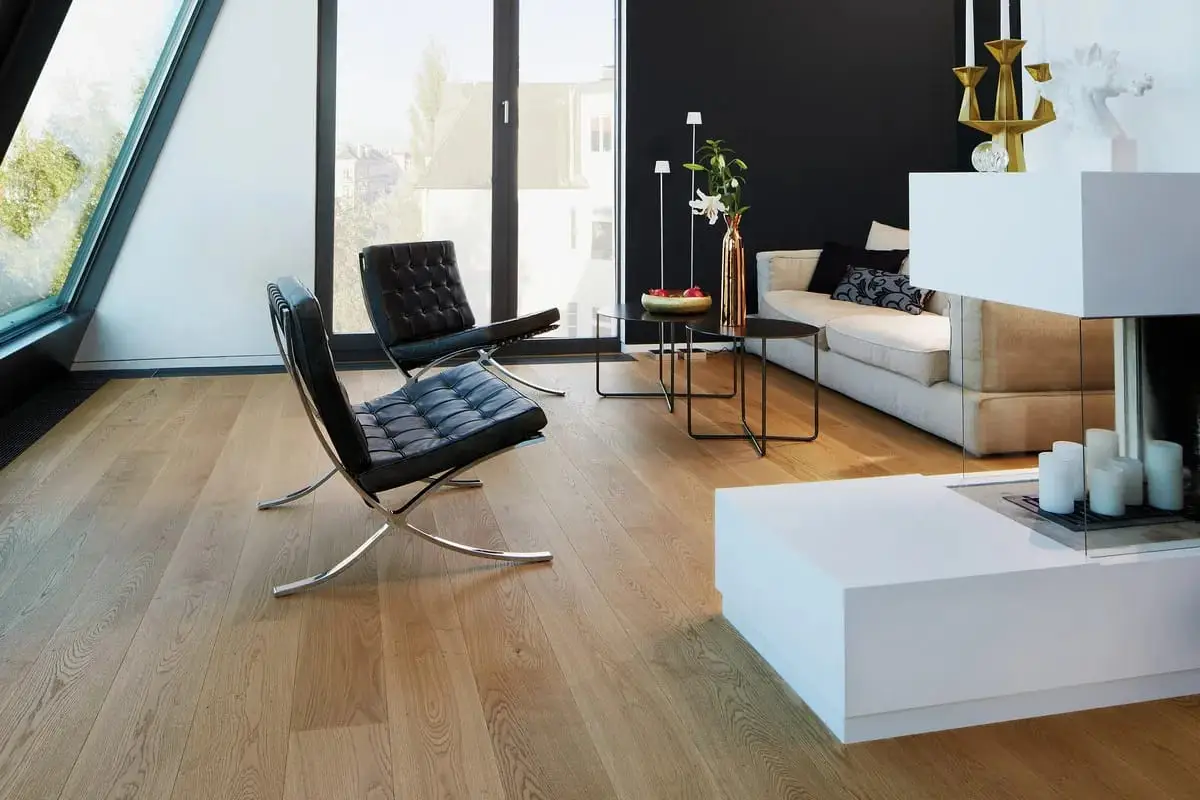 Wohnzimmer mit breiten Eichendielen, dunkler Wand und Ledersessel